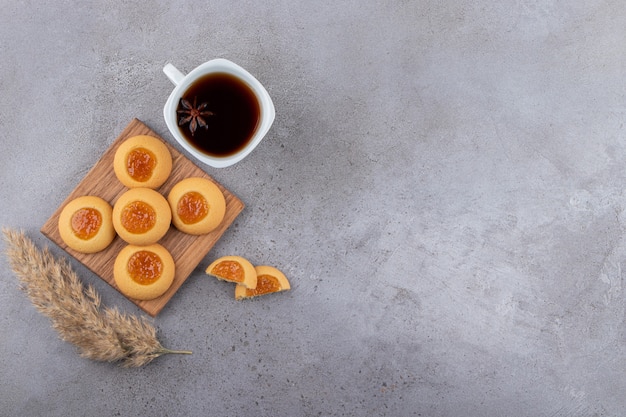 Kopje thee en zoete ronde koekjes op stenen tafel.