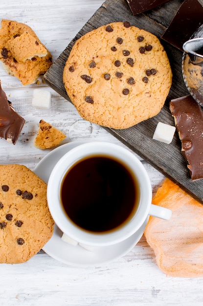 Kopje thee, koekjes op witte houten tafel