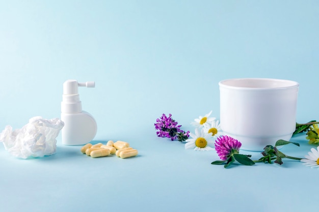 Kopje thee met bloemen kamille en bloeiende sally en pillen, spray voor loopneus en keel. seizoensgebonden ziekten en behandeling van verkoudheid, griep, hitte. kruidengeneeskunde versus conventionele geneeskunde.