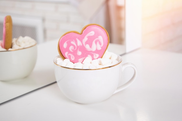 Kopje thee met cake in de vorm van hart en marshmallow
