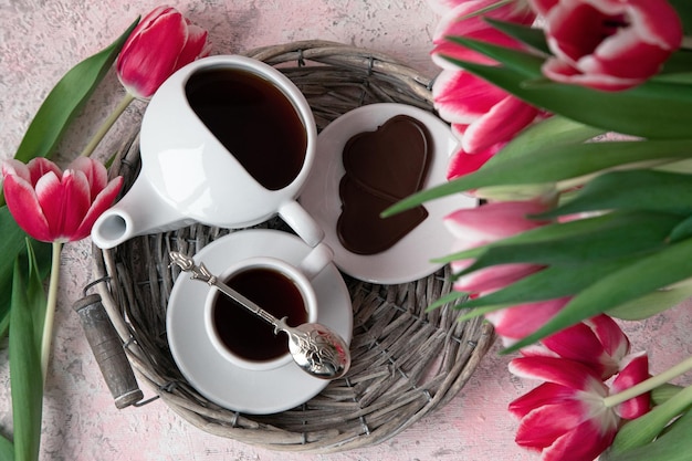 Kopje thee met chocolade en tulpen