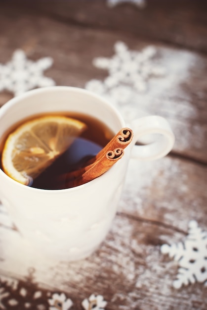 Kopje thee met een citroen en kaneel op Kerstmis achtergrond