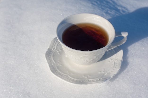 Kopje thee voor het ontbijt op sneeuwachtergrond buiten