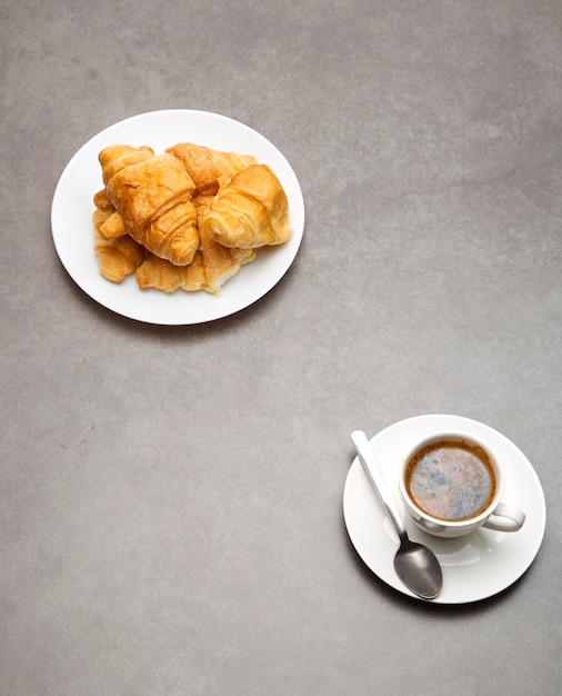 Kopje verse koffie met croissants op donkere achtergrond