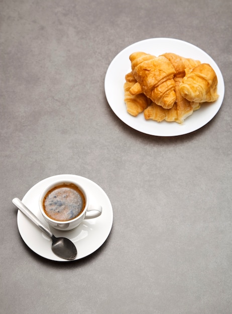 Kopje verse koffie met croissants op donkere achtergrond