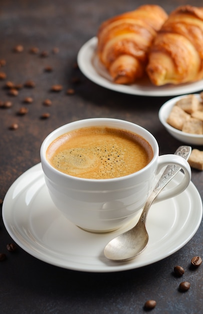 Kopje verse koffie met croissants op donkere achtergrond