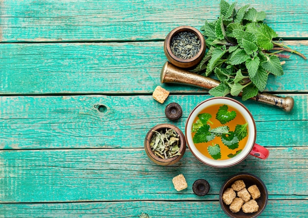 Kopje verse kruidenthee met melissa op houten tafel. Kruidenthee ingrediënten