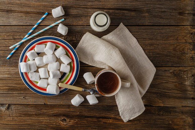 Kopje warme chocolademelk met marshmallows op de houten tafel, bovenaanzicht