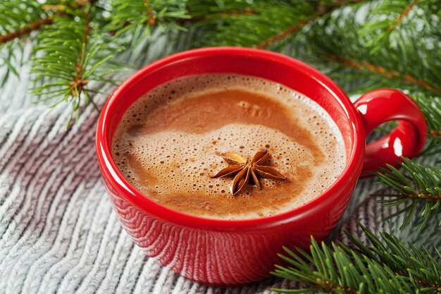 Kopje warme chocolademelk of warme chocolademelk op gebreide achtergrond met traditionele sparrendrank voor de winter