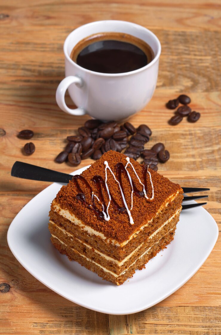 Kopje warme koffie en honingcake op oude houten tafel