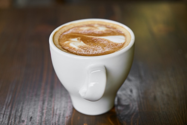 Kopje warme koffie latte op een houten tafel