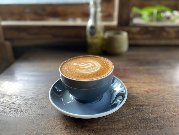 kopje warme koffie op houten tafel, latte art