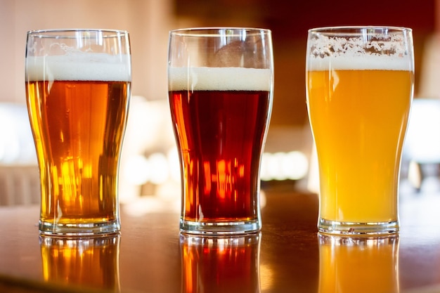 Kopjes bier op een houten tafel met een onscherpe achtergrond