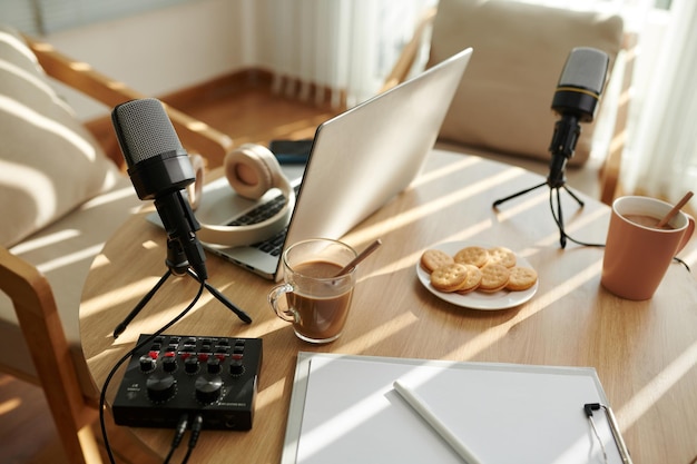 Foto kopjes koffie en koekjes klaargemaakt voor podcaster en zijn gast