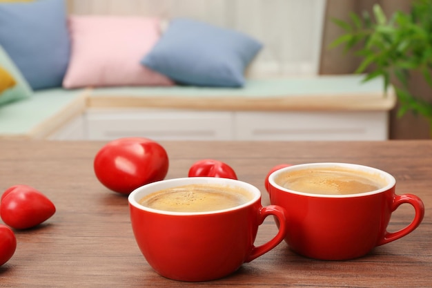 Kopjes koffie met hartjes op houten tafel