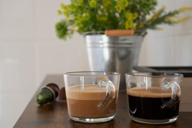 Kopjes latte en zwarte koffie met nespresso-capsules