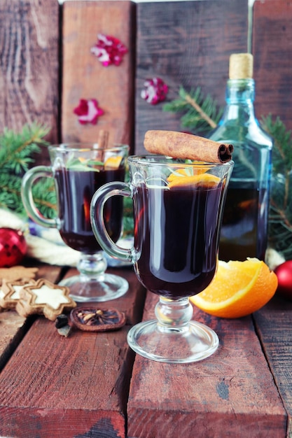 Kopjes met glühwein Kerstversiering Spar takken op een houten achtergrond