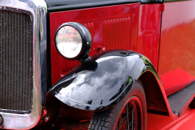 Koplamp en radiator van vintage rode auto ckoseup.