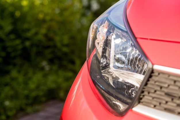 Koplampen en motorkap van sport rode auto buiten concept van auto detaillering en verf bescherming achtergrond