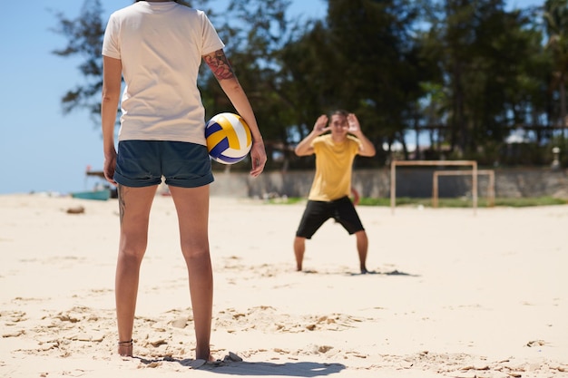 Koppel aan het volleyballen op het strand