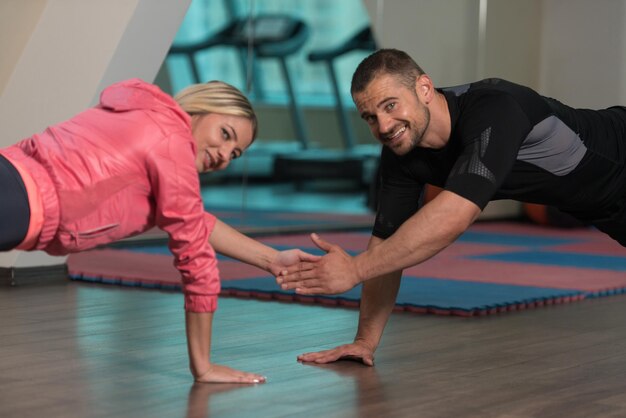Koppel doet push-ups als onderdeel van bodybuilding-training in de sportschool