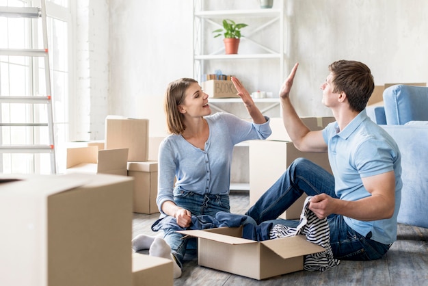 Foto koppel elkaar high-fiving tijdens het inpakken om te verhuizen