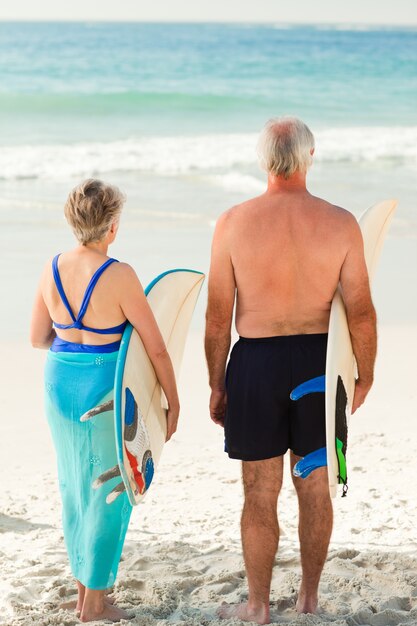 Koppel met hun surfplank op het strand