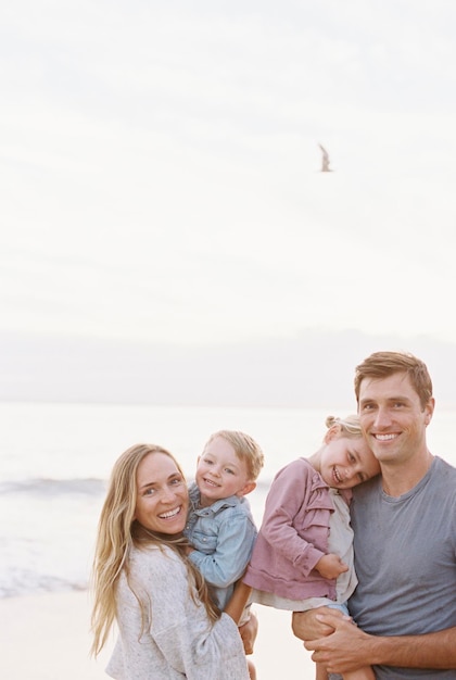 Koppel met kinderen op een zandstrand aan de oceaan