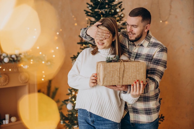 Koppel met verrassingscadeau bij de kerstboom