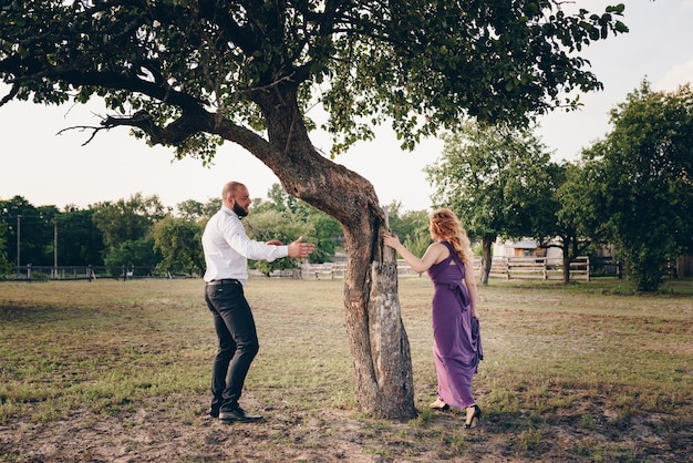 Koppel op een date. paarse jurk. bruid en bruidegom. loop in het veld. liefdesverhaal.