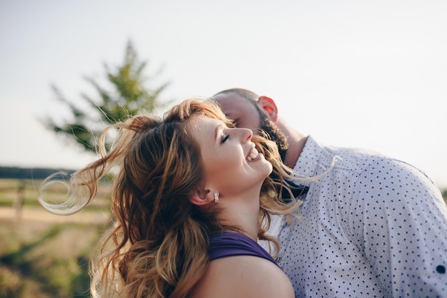 Foto koppel op een date. paarse jurk. bruid en bruidegom. loop in het veld. liefdesverhaal.