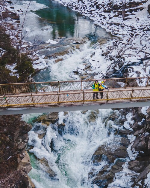 Koppel reizigers op de brug over de waterval kopieer ruimte