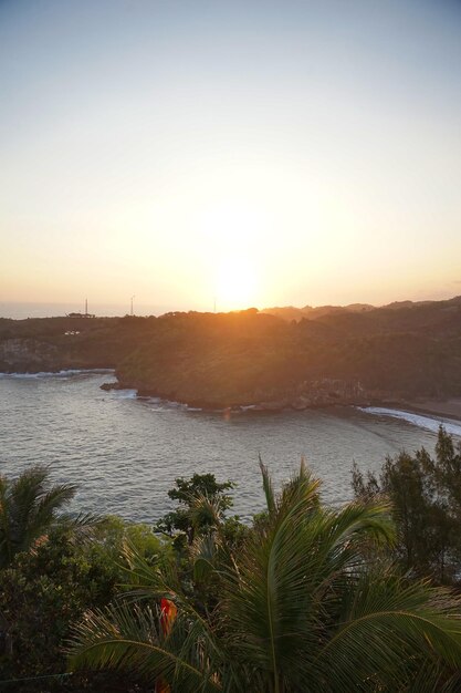 Foto koraalstrand tijdens de gouden zonsondergang baron beach wonosari gunungkidul