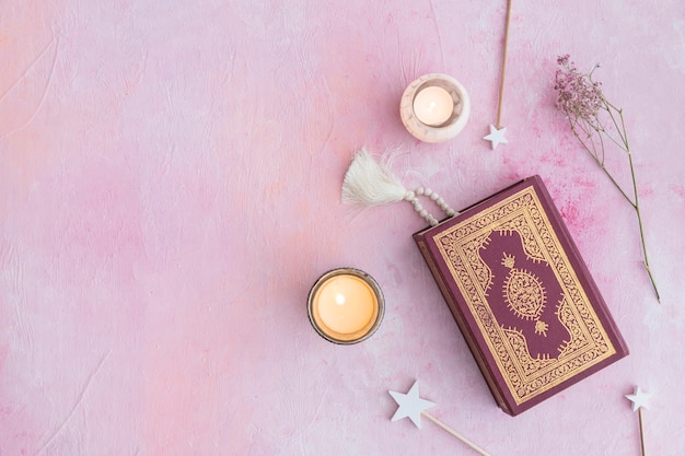 Koran and candles on pink 