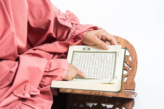 Foto koran in de hand het heilige boek van de moslims openbaar voorwerp van alle moslims koran in de handen van de moslimvrouw