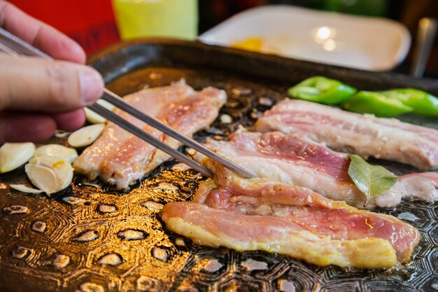Koreaanse BBQ rauw rundvlees op de grill en groenten met stokje. Yakiniku Koreaans eten.