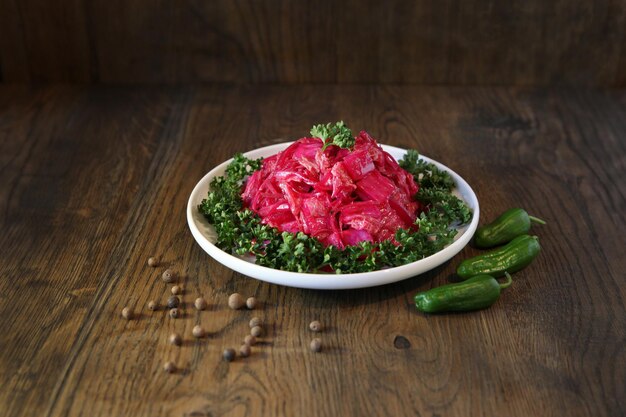 Koreaanse koolsalade met bieten op een bord met peper. Heerlijke Aziatische gerechten