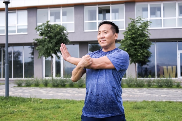 Koreaanse man strekt zich uit tegen de achtergrond van de stad.