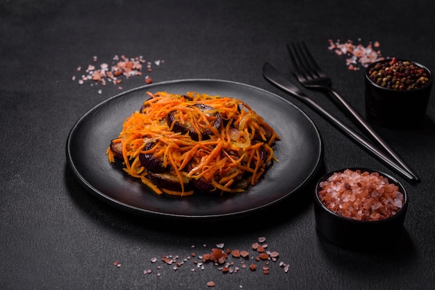 Koreaanse salade met aubergine, wortelen, knoflookkruiden en kruiden op een donkere betonnen ondergrond