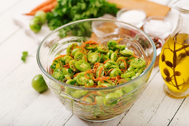 Koreaanse salade van groene tomaten en wortelen.