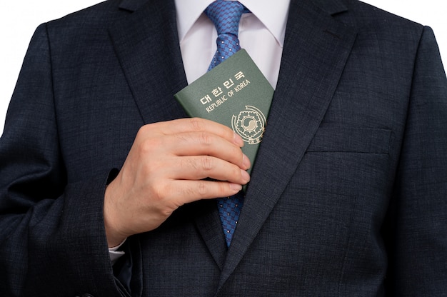 Корейский бизнесмен, держа в руке корейский паспорт.