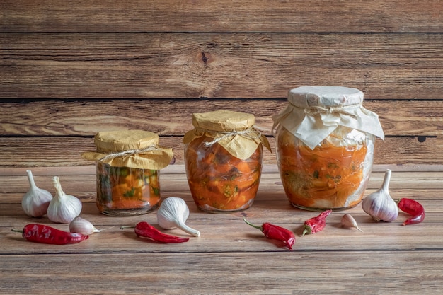 Korean kimchi in jars on a wooden table.