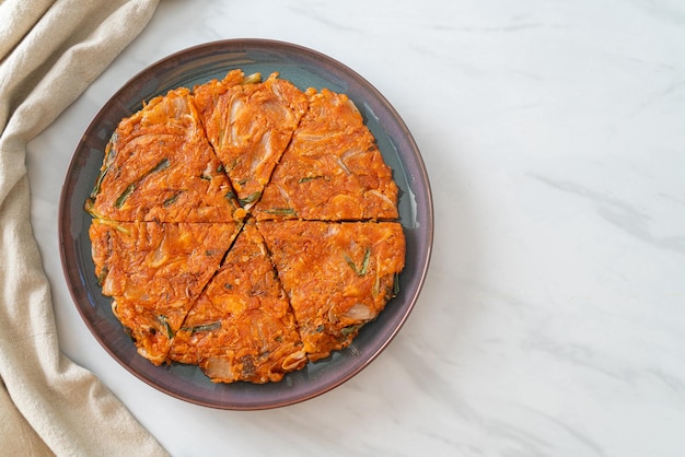 Photo korean kimchi pancake or kimchijeon - fried mixed egg, kimchi, and flour - korean food style