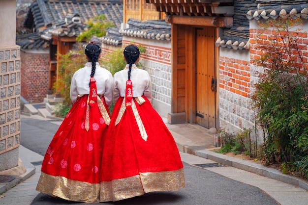 韓服や韓国の韓国人女性がソウルの古代の町で服を着て歩く