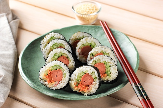korean roll gimbap (kimbob or kimbap) made from steamed white rice (bap) and various other ingredients, such as kyuri, carrot, sausage, crab stick, or kimchi and wrapped with seaweed laver. copy space