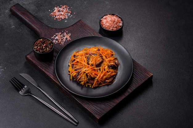 Korean salad with eggplant carrots garlic spices and herbs on a dark concrete background