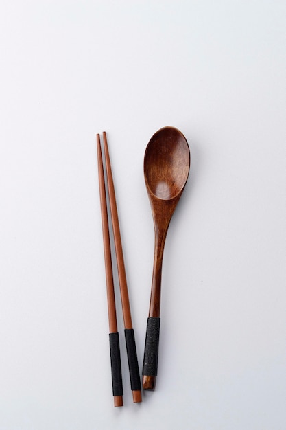 写真 白いテーブル、コピースペース、食べるコンセプトに分離された韓国のスプーンと箸の木製カトラリー