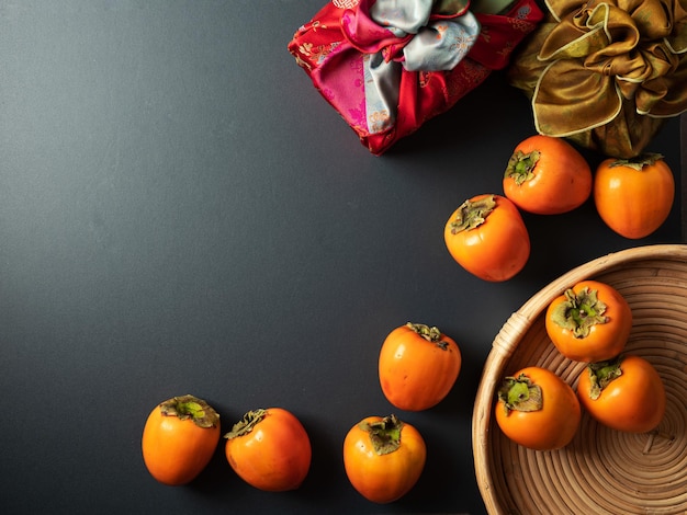 Korean traditional gift with persimmons on dark background