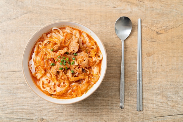 Tagliatelle coreane di ramen udon con carne di maiale in zuppa di kimchi - stile di cibo asiatico