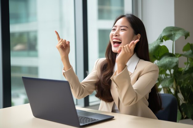 Korean woman in front of the computer happy because she has just received a message approving a gran